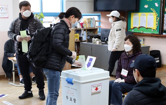 한 인천시민이 15일 인천 연수구 송도1동 제4투표소에서 비닐장갑을 끼고 투표함에 투표용지를 넣고 있다. 인천=뉴시스