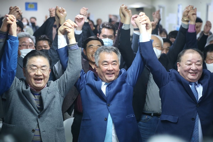 15일 총선 개표 결과 당선이 유력한 제주시갑 선거구 더불어민주당 송재호 후보(가운데)가 지지자들과 손을 잡고 만세를 부르고 있다. 제주=연합뉴스