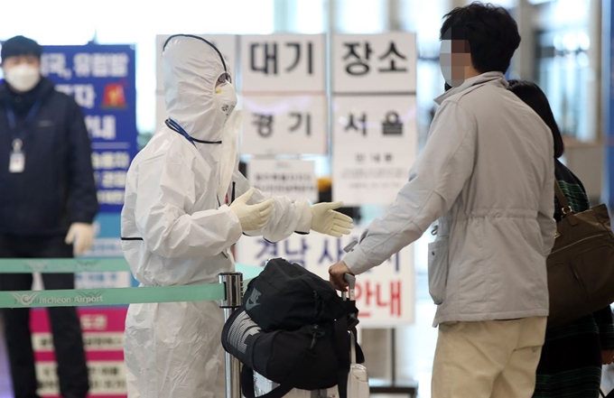 지난달 31일 인천국제공항 1터미널 입국장에서 인천공항공사 직원이 독일 프랑크푸르트발 항공기로 귀국한 코로나19 무증상 내국인들에게 교통편을 안내하고 있다. 연합뉴스