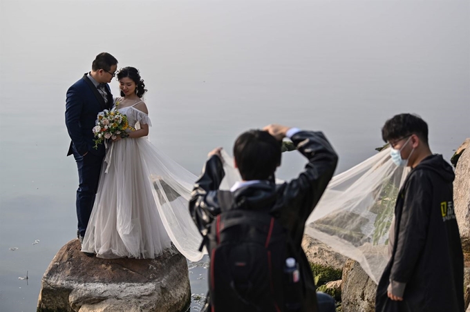 중국 후베이성 우한에서 19일 결혼을 앞둔 커플이 야외에서 웨딩 사진을 찍고 있다. 우한=AFP 연합뉴스