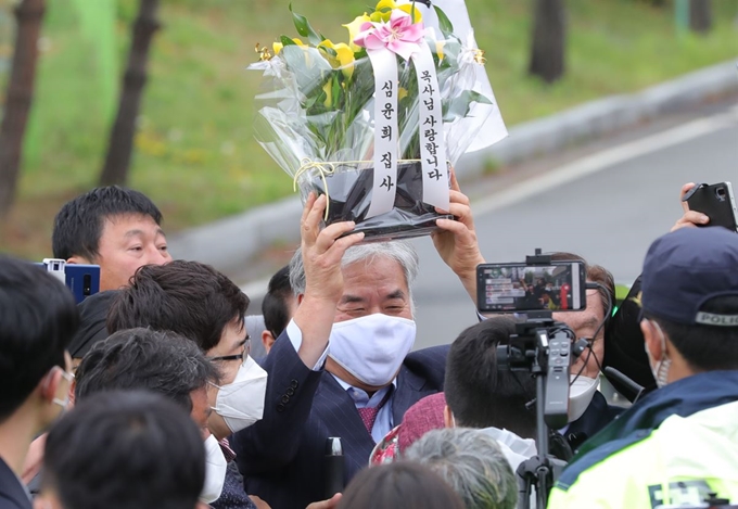 광화문 집회 등에서 특정 정당의 지지를 호소한 혐의로 구속되었던 전광훈 한국기독교총연합회 대표회장 목사가 20일 오후 경기도 의왕 서울구치소에서 보석돼 나오며 지지자가 준 꽃을 들어올리고 있다. 연합뉴스