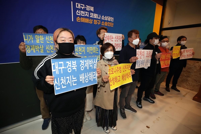 13일 오후 대구시 수성구 대흥동 대구 스타디움 몰에서 열린 대구·경북 신천지 코로나(신종 코로나바이러스 감염증) 소상공인 손해배상 청구 기자회견에서 소송인단이 손 피켓을 들고 신천지에 피해 보상을 촉구하고 있다. 소송인단은 1차 모집에만 약 1천여 명이 모였으며 신천지예수교회를 상대로 매출 감소·정신적 위로금 포함 100억 원대의 피해 보상을 청구할 계획이다. 대구=연합뉴스