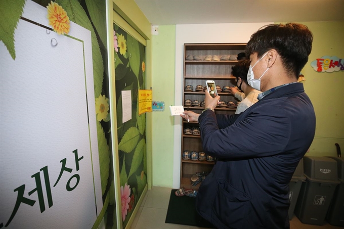 12일 대구시 중구의 폐쇄된 한 신천지 교육 시설에서 중구청과 대구시설공단 관계자들이 사람들의 출입 여부를 점검하고 있다. 대구=연합뉴스