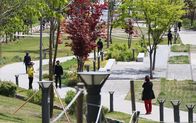 정부의 '고강도 사회적 거리두기'가 완화된 가운데 24일 서울 용산구 경의선 숲길 공원에서 시민들이 산책을 즐기고 있다. 연합뉴스