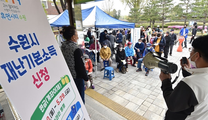 경기도 재난기본소득 방문 신청일인 지난 4월 20일 수원시 팔달구의 행정복지센터에서 신청자들이 번호표를 뽑고 대기하고 있다. 뉴시스