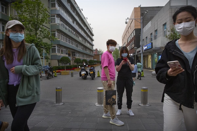 24일 중국 베이징에서 쇼핑가를 찾은 시민들이 마스크를 쓰고 있다. 베이징=AP 연합뉴스