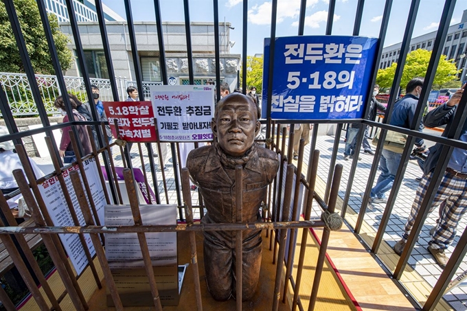 27일 오전 광주 동구 지산동 광주지방법원 앞에서 5·18 민주화운동 유가족이 '전두환 동상'을 철제감옥에 넣고 있다. 광주=서재훈 기자