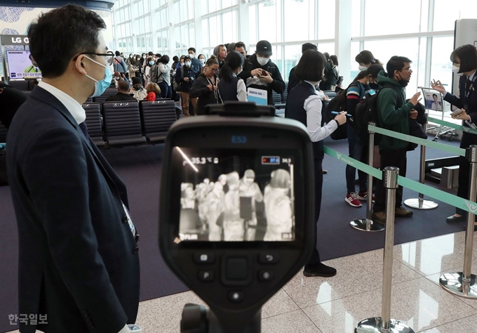 [저작권 한국일보]지난 2월 28일 오후 인천국제공항 제2여객터미널 인천발 로스앤젤레스(LA)행 KE017편 탑승구 앞에서 대한항공 직원들이 열화상 카메라를 이용, 탑승객의 발열 여부를 확인하고 있다. 영종도=고영권 기자