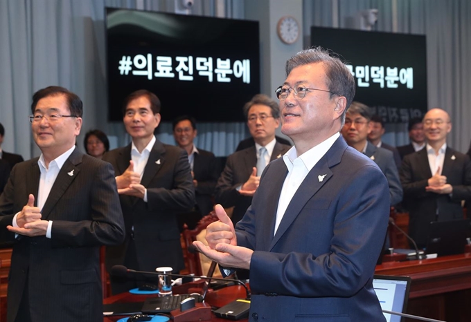 문재인 대통령이 27일 오후 청와대에서 수석·보좌관 회의를 주재하기에 앞서 참석자들과 함께 신종 코로나바이러스 감염증(코로나19) 의료인에게 고마움을 전하는 ‘덕분에 챌린지’에 참여하고 있다. 연합뉴스