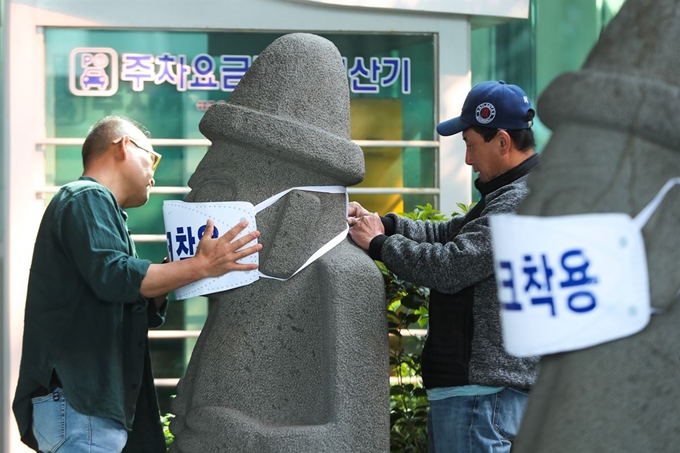 정부가 고강도 사회적 거리두기를 제한적으로 완화한 가운데 28일 오전 제주국제공항에 서 있는 돌하르방이 신종 코로나바이러스 감염증(코로나19) 예방 마스크를 쓰고 있다. 제주도는 오는 30일부터 시작되는 황금연휴 기간 동안 '코로나19' 주의 환기 차원에서 도내 관광지 40여기의 돌하르방에 마스크를 씌우기로 했다. 뉴시스