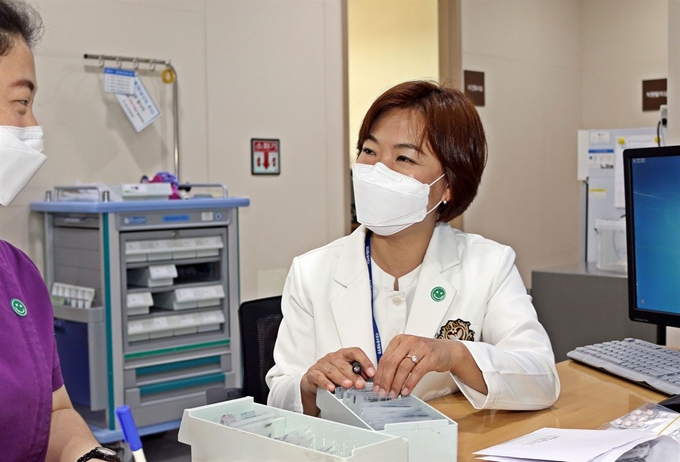 지난 2월말 대구 남구 보건소 선별진료소에서 신종 코로나바이러스 감염증(코로나19) 진료지원 근무 중 신종 코로나에 감염돼 서울대병원에서 격리치료를 받고 이달 16일 직장인 국립교통재활병원에 복귀한 김기숙 간호사(사진 오른쪽)가 환한 얼굴로 근무하고 있다. 국립교통재활병원 제공