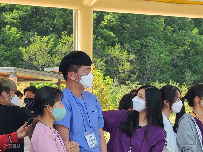 전국 15개 생활치료센터 중 처음 문을 열었던 대구 중앙교육연수원에 파견된 한 남성 간호사가 29일 격리환자들을 대구동산병원으로 떠나 보내면서 눈물을 흘리자 주위 간호사들이 위로하고 있다. 대구=김민규 기자