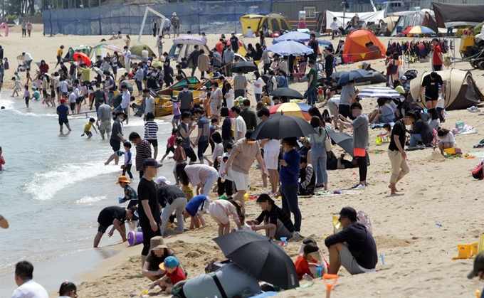 황금연휴 둘째 날인 1일 낮 기온이 크게 올라간 동해안 주요 해수욕장 해변에 수많은 행락객이 몰려 강원 속초해수욕장 해변이 인파로 붐비고 있다. 연합뉴스