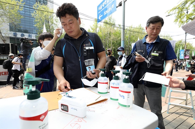 제130주년 노동절을 맞은 1일 서울 종로구 마로니에공원 앞에서 열린 '2020 세계 노동절 대회'에서 민주노총 조합원들이 참가자들을 대상으로 체온측정 및 마스크 배부를 하고 있다. 뉴스1