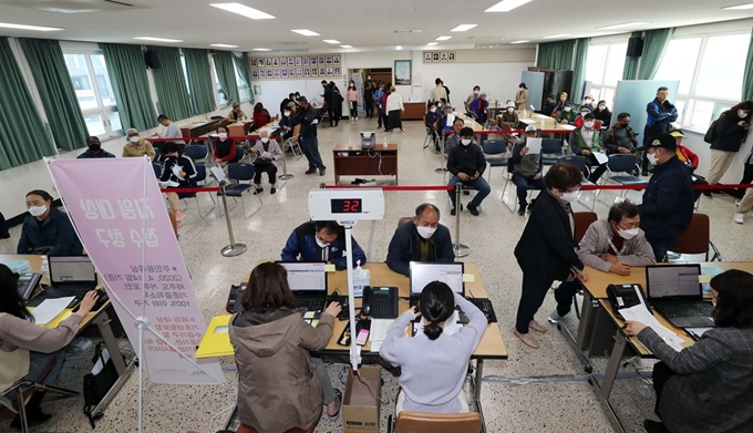 지난달 27일 오전 제주시 노형동주민센터에서 시민들이 이날부터 현장접수를 시작한 제주형 재난긴급생활지원금 신청을 하고 있다. 뉴스1.