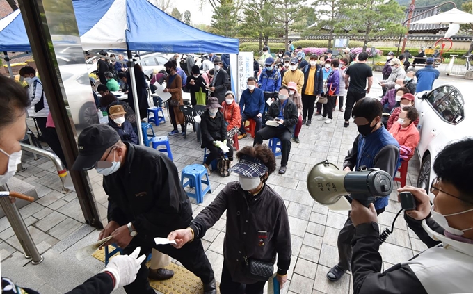 지난달 20일 경기 수원시 팔달구의 한 행정복지센터 앞에서 경기도 재난기본소득 선불카드 신청을 하려는 시민들이 줄을 서 있다. 신종 코로나바이러스 감염증(코로나19) 사태로 위축된 실물경제 회복을 위해 경기도와 서울시 등에 이어 정부도 이달 13일 전 국민에게 긴급재난지원금을 지급하기 시작한 가운데, 국민기본소득제 도입 여부를 둘러싼 사회적 논의가 본격화하고 있다. 수원=뉴시스