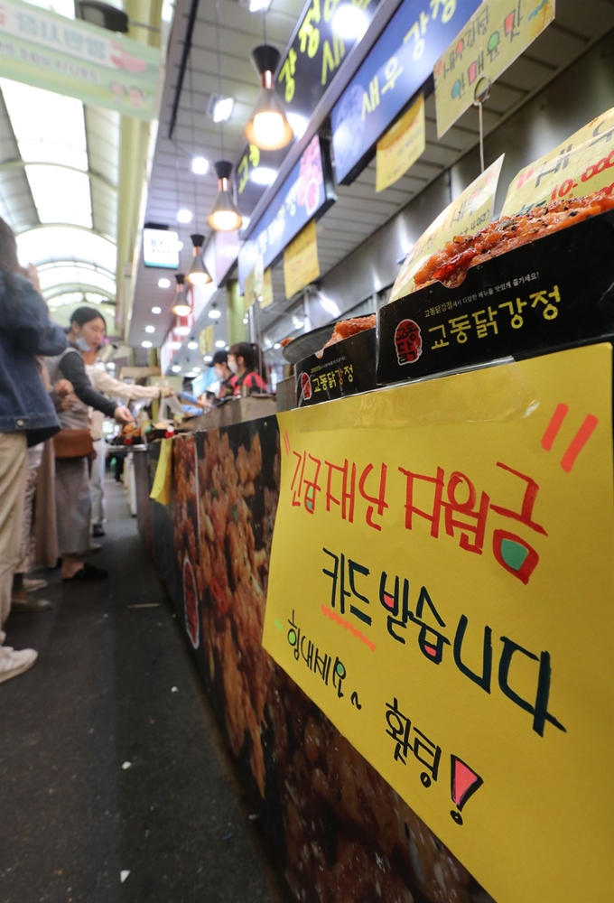 17일 서울의 한 전통시장 매장 앞에 ‘긴급재난지원금’의 사용이 가능하다는 안내문이 게시돼 있다. 정부는 신종 코로나바이러스 감염증(코로나19) 사태로 위축된 실물경제의 회복을 위해 지난 13일부터 전 국민을 상대로 가구당 40만~100만원씩의 지원금을 지급하고 있다. 뉴스1