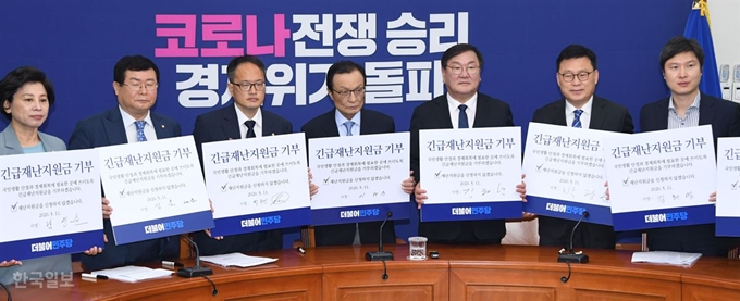 이해찬 더불어민주당 대표와 김태년 원내대표 등 당 지도부가 11일 오전 서울 여의도 국회에서 열린 최고위원회의에서 긴급재난지원금 기부 서약서를 들어 보이고 있다. 오대근 기자