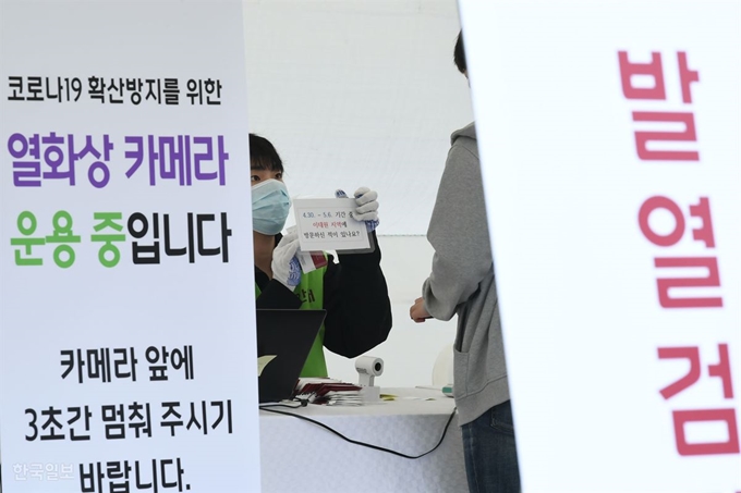 12일 오전 서울 성북구 고려대학교 정문 앞에 설치된 '발열검진소'에서 한 직원이 발열검사를 마친 학생에게 이태원지역 방문여부를 묻고 있다. 왕태석 선임기자