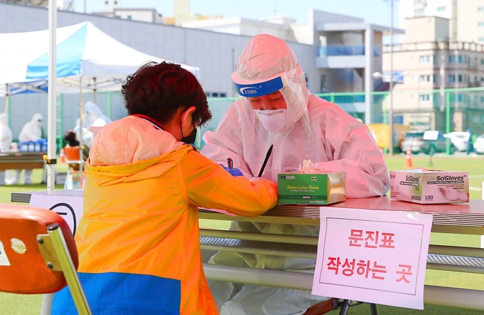 13일 인천 미추홀구청 운동장에 설치된 선별진료소에서 한 어린이가 문진표를 작성하고 있다. 미추홀구 제공