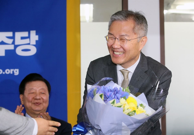 열린민주당 최강욱 신임 당 대표가 12일 서울 여의도 당사에서 축하 꽃다발을 받고 있다. 연합뉴스