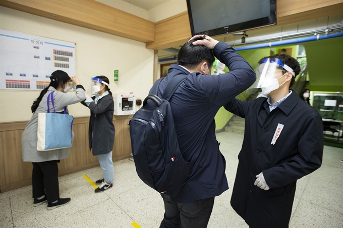 국가공무원 5급 공채 시험이 실시된 16일 오전 서울 시내 한 고사장에서 응시생들이 발열 검사를 받고 있다. 이 시험은 2월 29일로 예정돼 있었지만, 신종 코로나바이러스 감염증(코로나19)의 확산으로 미뤄졌다. 연합뉴스