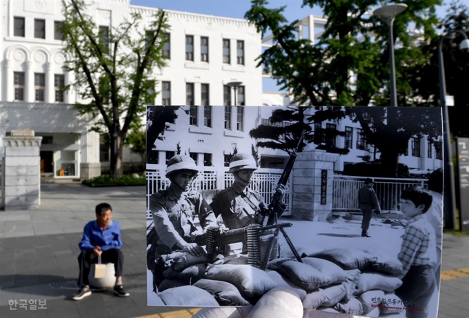 1980년 5월 27일 시민군을 전멸시킨 계엄군이 당시 전남도청 앞에서 경계근무를 서고 있는 천진난만하게 바라보는 어린이(흑백 사진)의 모습을 40년이 지난 11일 동일한 장소로 소환했다. 노인은 그날의 비극을 회상하기라도 하듯 한참을 말없이 앉아 있었다. 광주=서재훈 기자