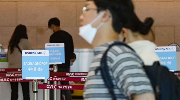 17일 서울 강서구 김포공항 국내선청사에 위치한 대한항공 체크인카운터 앞에서 마스크를 쓴 승객이 걸어가고 있다. 연합뉴스