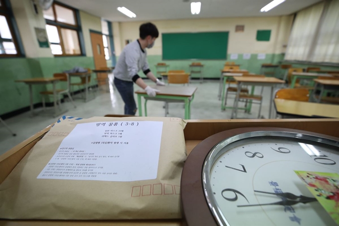 고3 등교개학을 이틀 앞둔 18일, 서울 종로구 경복고에서 한 교사가 책상을 시험 대형으로 배치하고 있다. 연합뉴스