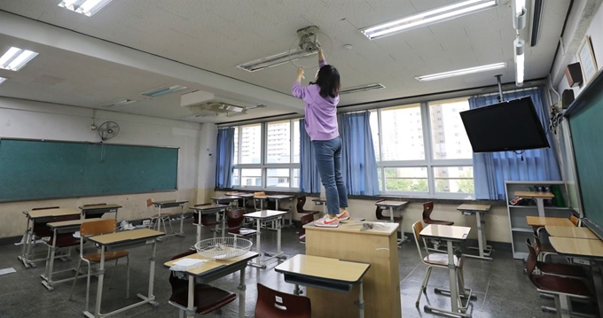 19일 서울 영등포구 여의도고등학교 3학년 교실에서 교사가 소독제로 선풍기를 닦고 있다. 뉴스1