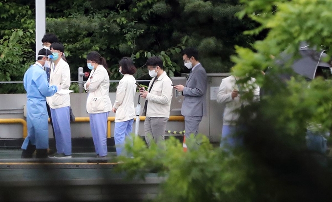 박원순 서울시장이 삼성서울병원 간호사 4명이 신종 코로나바이러스 감염증(코로나19)에 감염됐다고 밝힌 19일 강남구 삼성서울병원 야외주차장 옥상에 차려진 코로나19 검사소에서 의료진을 비롯한 병원 관계자 등이 검사를 위해 대기하고 있다. 연합뉴스