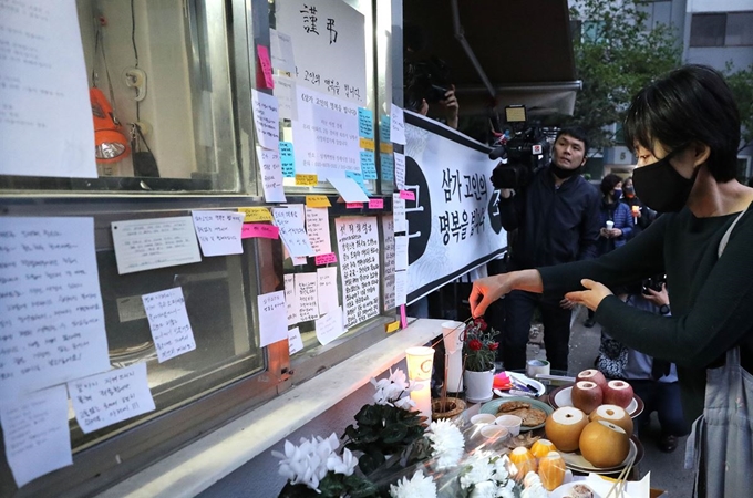 지난 11일 서울 강북구 아파트 경비실 앞에 차려진 분향소에서 주민들이 경비원의 죽음을 애도하며 촛불집회를 하고 있다. 뉴스1