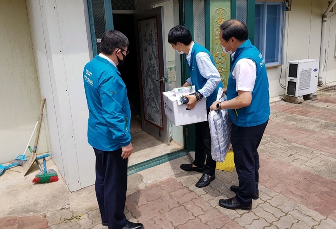 한국원자력환경공단 임직원들이 코로나19로 어려움을 겪고 있는 세대에 생필품 키트와 온누리상품권을 전달하고 있다. 환경공단 제공