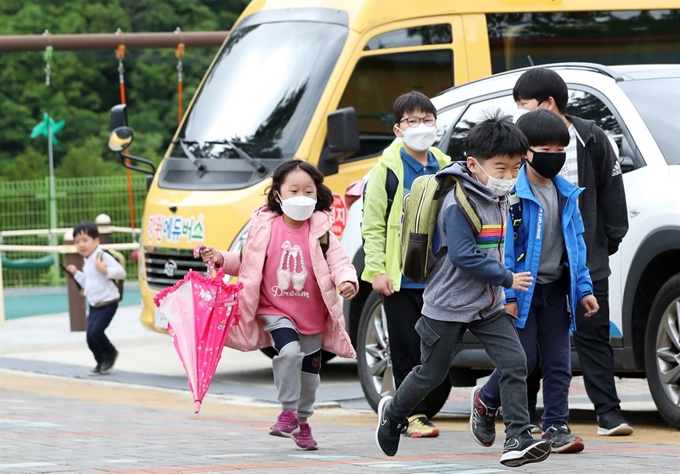 지난 20일 강원 춘천시 북산면 추곡초등학교에서 학생들이 통학버스에서 내려 교실로 향하고 있다. 교육부는 모든 학생이 등교해도 생활 속 거리 두기가 가능한 농산어촌 등의 전교생 60명 이하 소규모 학교는 조기에 등교 수업이 가능하도록 했다. 춘천=연합뉴스