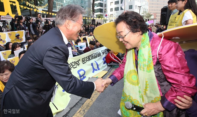 위안부 소녀상이 세워진 서울 종로구 일본 대사관 앞에서 일본군 위안부 문제 해결을 위한 정기 수요집회가 1,200 차례를 맞은 2015년 10월 문재인 당시 새정치민주연합 대표가 이용수 할머니와 인사를 나누고 있다. 한국일보 자료사진