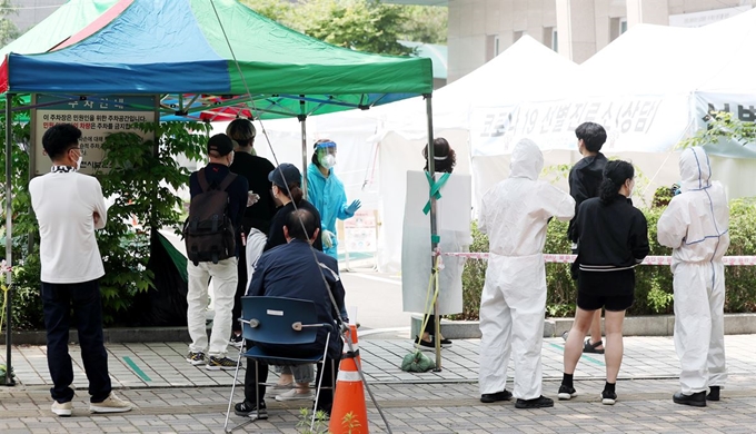 26일 오전 경기 부천시보건소 선별진료소에서 검사자들이 줄지어 검사를 기다리고 있다. 부천=연합뉴스