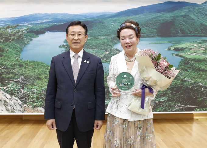 배우 김수미씨가 27일 오후 괴산군수실에서 이차영 군수로부터 홍보대사 위촉장을 받은 뒤 기념촬영을 하고 있다. 괴산군 제공