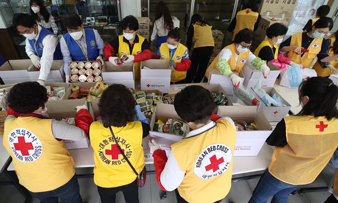 28일 오전 서울 성동구 대한적십자사 서울시지사에서 국제로타리 3640지구 회원과 적십자 봉사원들이 코로나19 극복을 위한 재난 취약계층 쉘터박스를 제작하고 있다. 마스크, 밑반찬, 영양제 등이 담긴 이 박스는 재난 취약계층 500가구에 전달될 예정이다. 연합뉴스