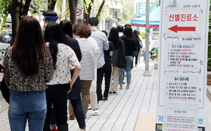 28일 오후 경기 부천시 중동 부천시보건소 선별진료소에서 시민들이 검사를 받기 위해 줄지어 서 있다. 부천=연합뉴스