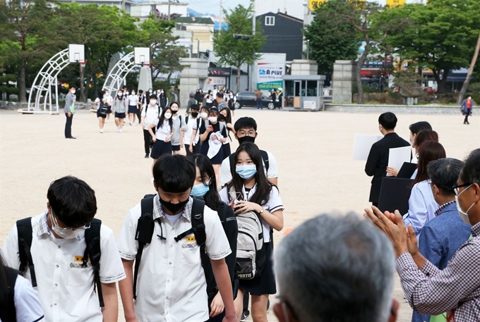 고등학교 1학년·중학교 2학년·초등학교 3∼4학년을 대상으로 한 3차 등교개학일인 3일 오전 경북 포항 남구 연일읍 영일고에서 교사들 환영 속에서 1학년 학생들이 올해 처음으로 등교하고 있다. 1학년 학생들은 그동안 신종 코로나바이러스 감염증(코로나19) 사태로 등교하지 못했다. 연합뉴스