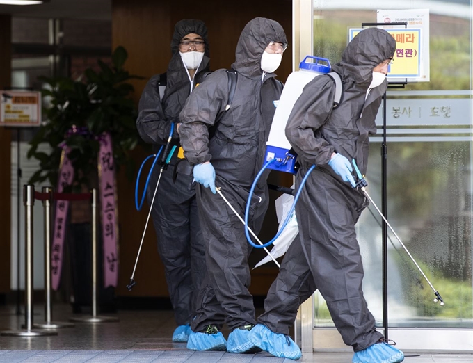 인천 인항고등학교에서 방역 관계자들이 작업을 마친 후 학교를 나서고 있다. 연합뉴스