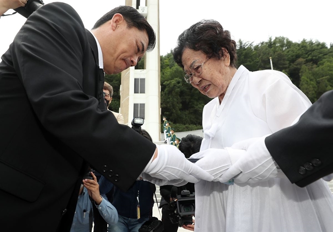 3일 대구 남구 충혼탑에서 열린 6ㆍ25 참전용사 고(故) 김진구 하사의 '호국의 영웅 귀환 행사'에서 허욱구 국방부 유해발굴감식단장(왼쪽)이 고 김 하사의 전사자 신원 확인 통지서를 김 하사의 부인에게 전달하고 있다. 연합뉴스