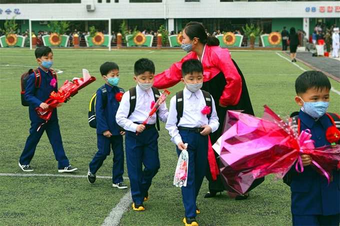 3일 개학한 평양시 대성구역 려명소학교에서 입학생들이 축하 꽃을 받아들고 교실로 향하고 있다. 통일의 메아리 홈페이지 캡처