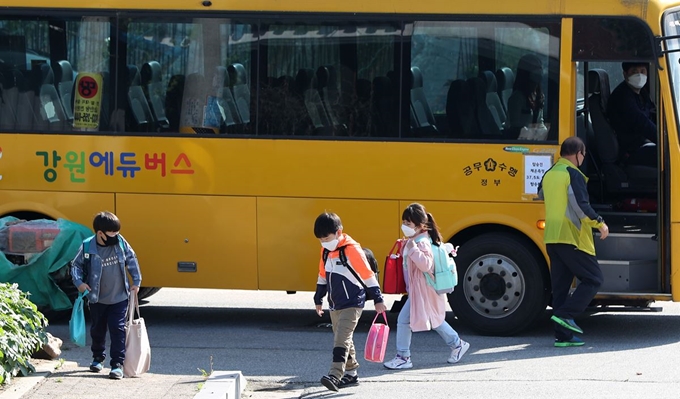 지난달 27일 오전 강원 춘천시 금병초등학교에서 학생들이 통학버스에서 내려 등교하고 있다. 춘천=연합뉴스