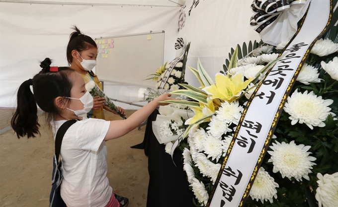 5일 충남 천안 한 초등학교에 마련된 아동학대 피해자 A군의 추모공간에서 두 어린이가 국화를 바치고 있다. A군은 1일 거짓말을 했다는 이유로 친부 동거인에 의해 7시간 이상 여행용 가방에 갇혔다가 사망했다. 뉴스1