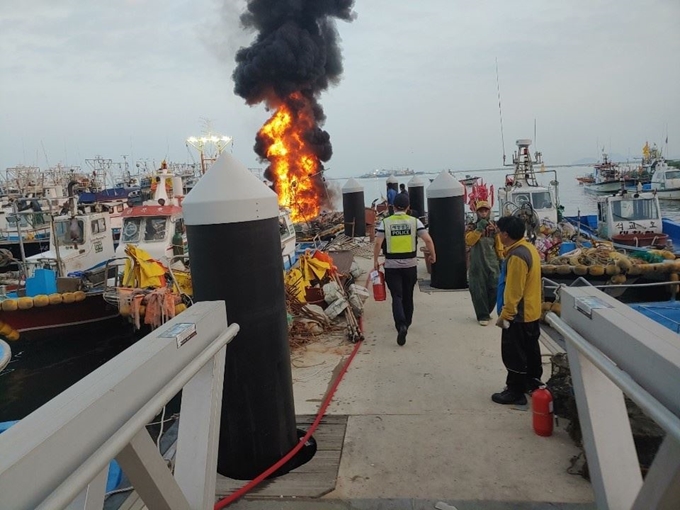 9일 오전 충남 보령시 대천항에 정박 중이던 어선에서 검은 연기와 함께 붉은 화염이 치솟고 있다. 보령해경 제공.