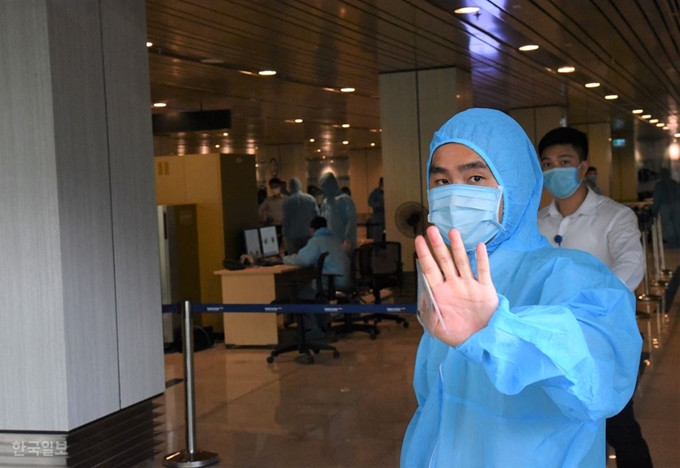 9일 한국 소상공인들이 베트남 번돈공항에 입국하기 위해 수속을 밟고 있는 가운데 현지 보건당국 관계자가 외부인의 청사 내 출입을 제한하고 있다. 꽝닌성=정재호 특파원