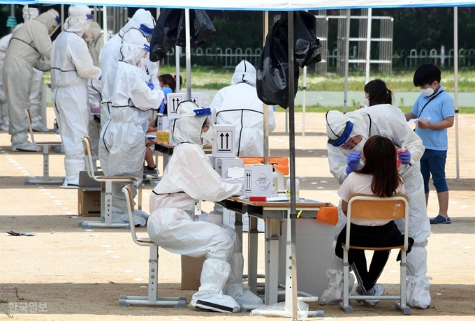 [저작권 한국일보]9일 재학생 중에 신종 코로나바이러스 감염증(코로나19) 확진자가 나온 인천 미추홀구 인천문학초등학교 운동장에 설치된 선별진료소에서 학생들이 검사를 받고 있다. 고영권 기자