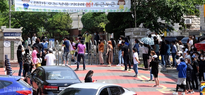 [저작권 한국일보] 재학생 가운데 신종 코로나바이러스 감염증(코로나19) 확진자가 나온 인천 미추홀구 인천문학초등학교 정문 앞에서 9일 학부모들이 코로나19 진단 검사를 마치고 나올 자녀들을 기다리고 있다. 고영권 기자