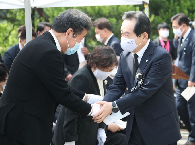 정세균(오른쪽) 국무총리와 이낙연 더불어민주당 의원이 10일 오전 서울 동작구 국립서울현충원에서 열린 고(故) 이희호 여사 1주기 추도식에서 만나 악수하고 있다. 연합뉴스